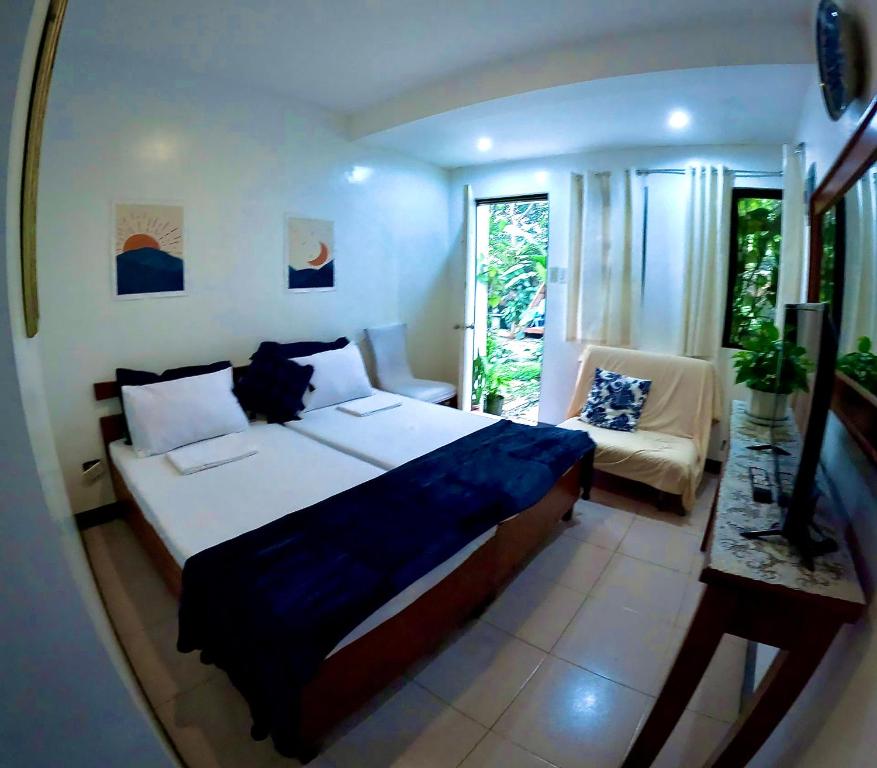 a bedroom with a large bed and a mirror at Auntie Gigi's Place in Tagaytay