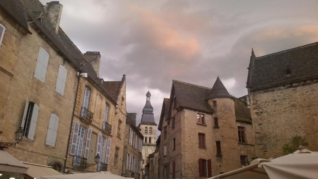 a group of buildings in a city with a cloudy sky at PETITS ANGES in Sarlat-la-Canéda