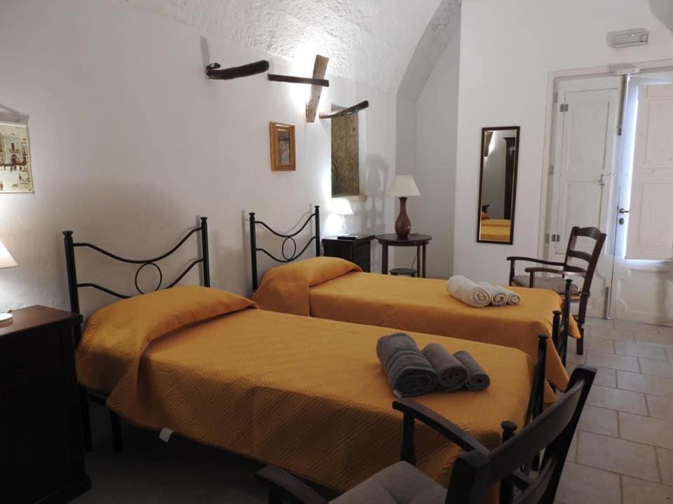 普雷西切的住宿－TRE SORELLE AFFITTA CAMERE，一间卧室设有两张带黄床单和镜子的床