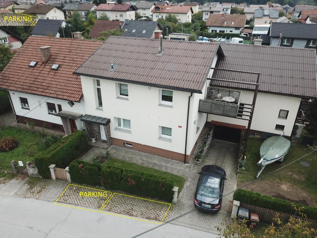 une maison blanche avec une voiture garée devant elle dans l'établissement Apartment Milena, à Maribor