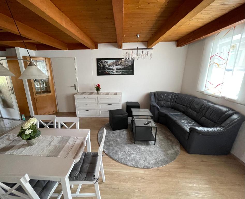 a living room with a black leather couch and a table at TM Apartment in Eibiswald