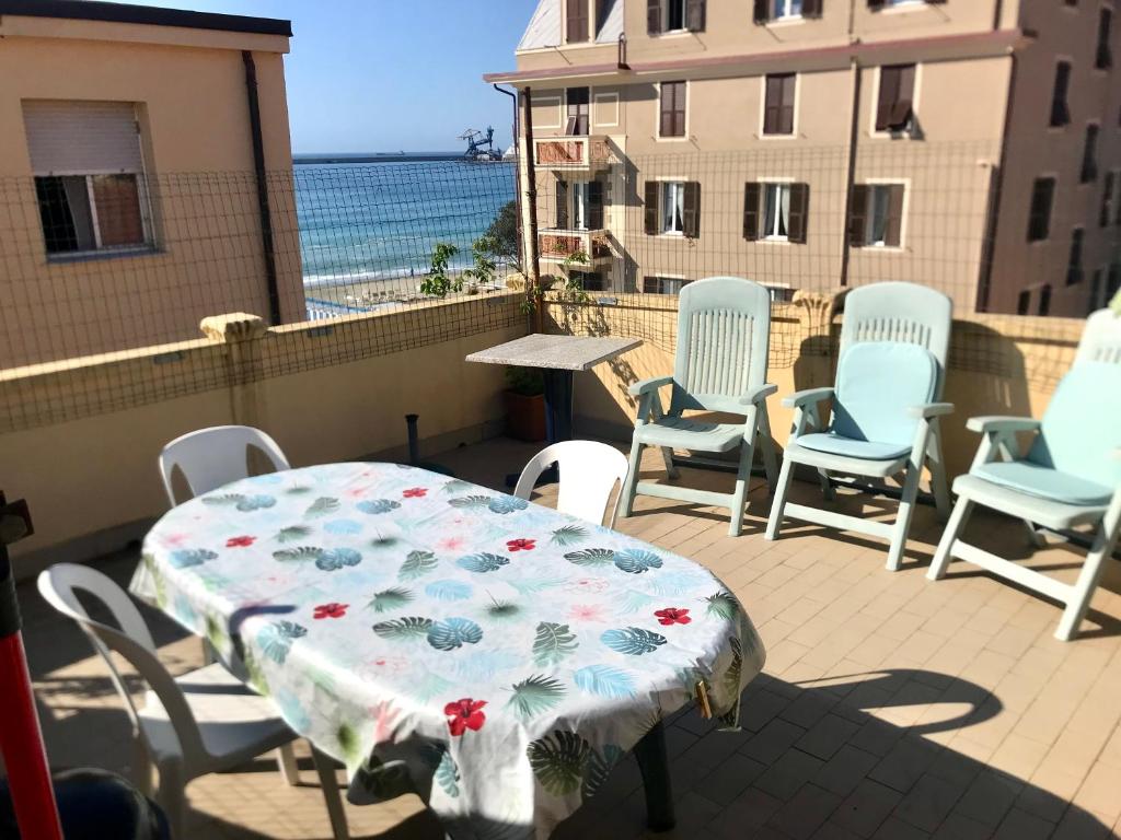 uma mesa e cadeiras numa varanda com o oceano em Casa Gaia em Albissola Marina