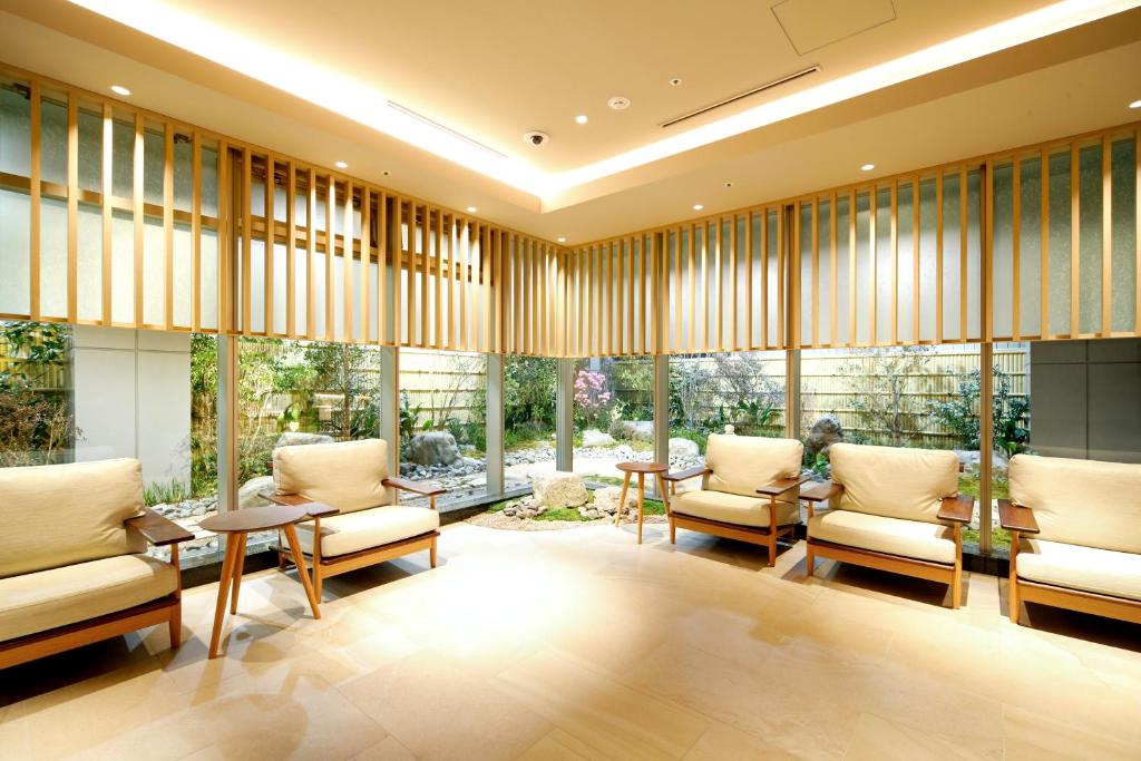 Habitación grande con sillas, mesas y ventanas. en Travelodge Kyoto Shijo Kawaramachi en Kioto
