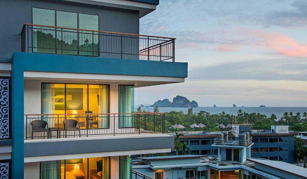een gebouw met een balkon met uitzicht op de oceaan bij AVA SEA Resort Krabi, Ao Nang Beach in Ao Nang Beach