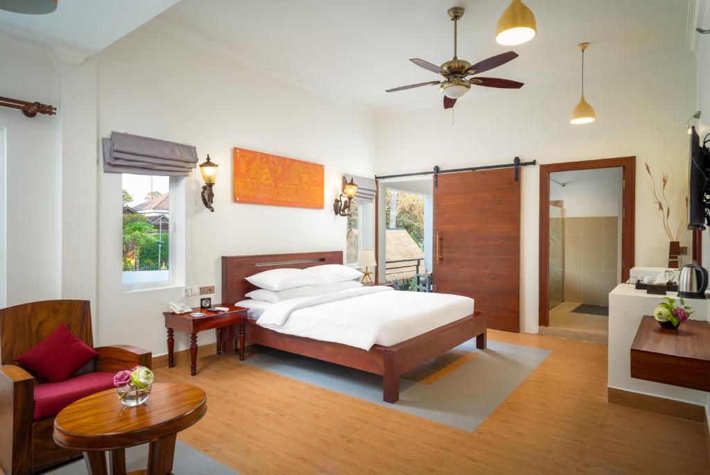 a bedroom with a bed and a living room at Sala Siem Reap Hotel in Siem Reap