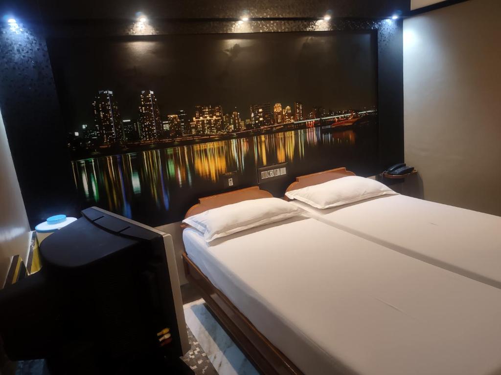 a bed in a room with a view of a city at Krishna Lodge in Tiruchchirāppalli