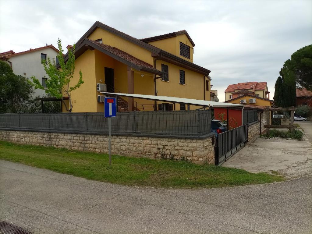 a house with a fence and a basketball hoop at Apartments Ingrid in Novigrad Istria