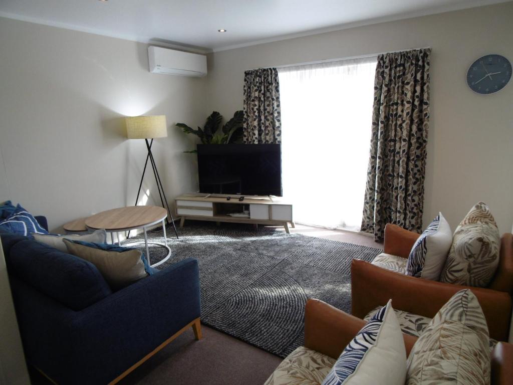 ein Wohnzimmer mit einem Sofa und einem TV in der Unterkunft Cambridge Bed & Breakfast in Cambridge