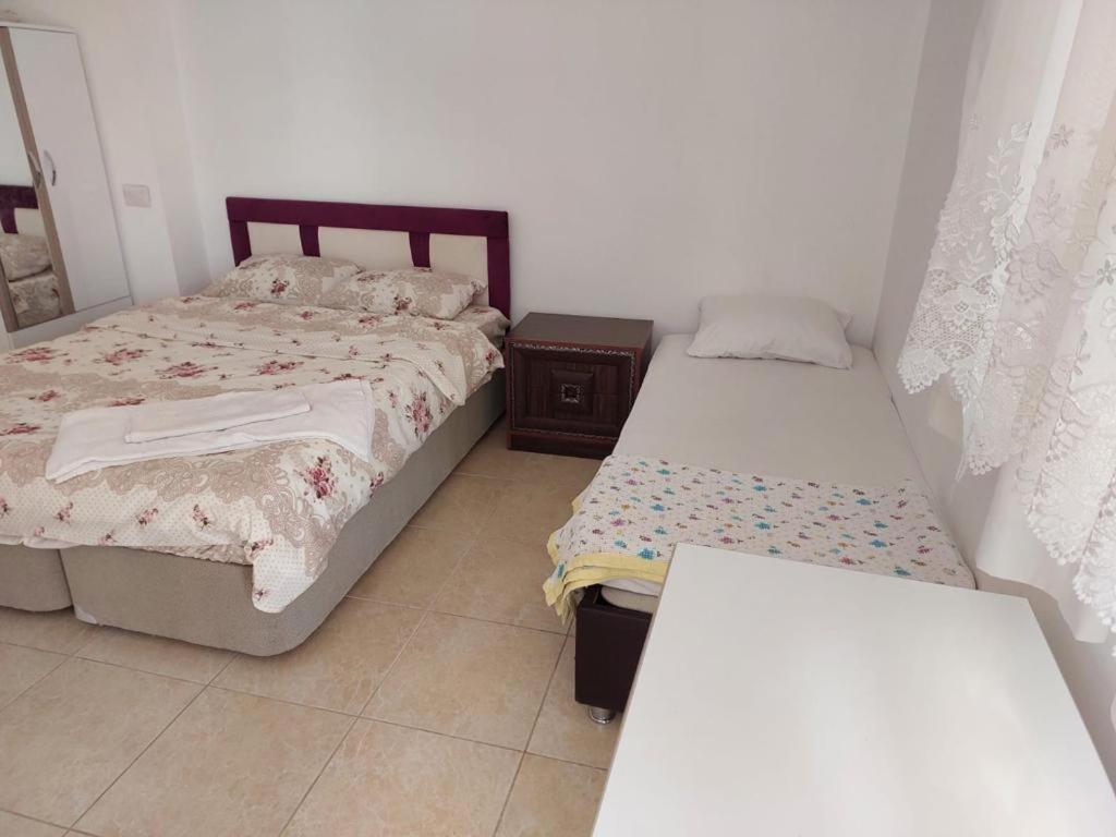 a bedroom with two beds and a table in it at Salda Gölüne çok yakın in Yeşilova