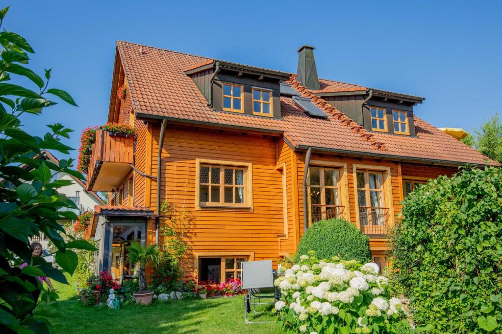 una grande casa in legno con fiori nel cortile di Ferienwohnung Schwatlo a Mistelgau
