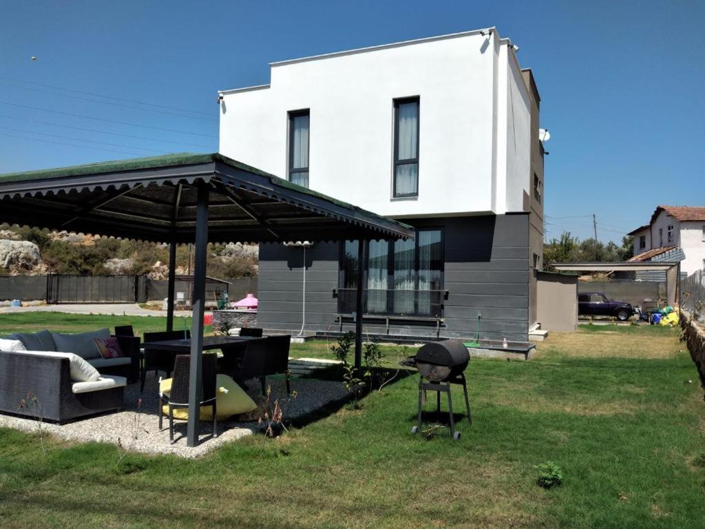 uma casa com um pátio com uma mesa e um grelhador em Sakın bir ortamda 3 odalı villa em Antalya