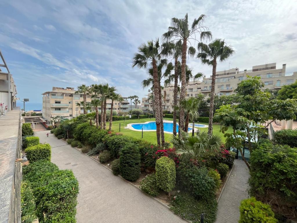 a view of a resort with a swimming pool and palm trees at Altos del Toril 2 habitaciones Wifi y Parking in Torremolinos
