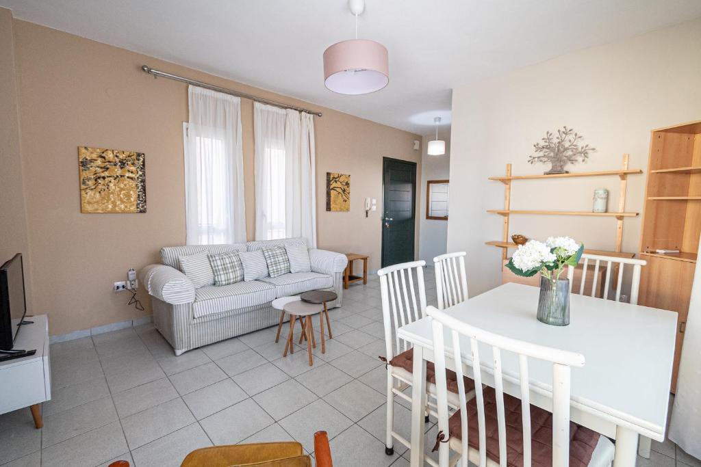 een woonkamer met een bank en een tafel bij Antonia Apartment by RentalsPro- Nea Moudania Halkidiki in Nea Moudania