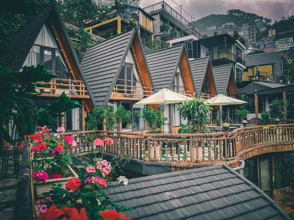 a house on a hill with flowers and umbrellas at Tuong Vi Homestay - Venuestay in Vĩnh Phúc