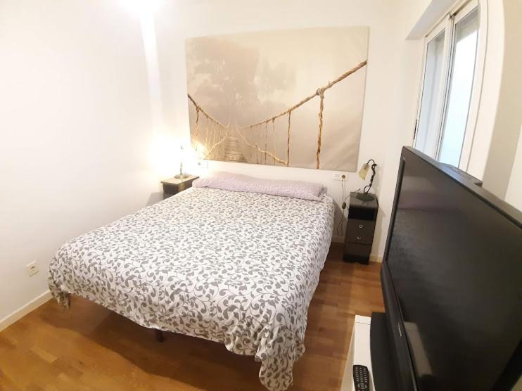 a bedroom with a bed and a flat screen tv at APARTAMENTO PATRICIA in Murcia