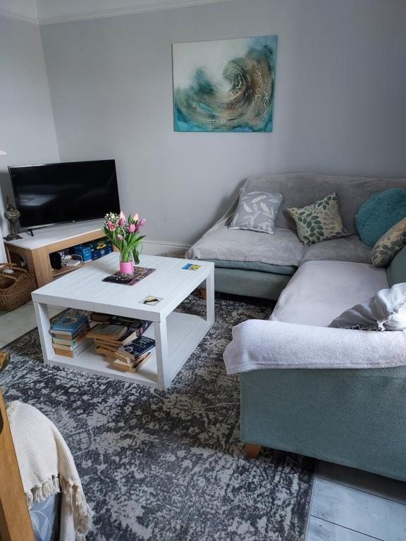 a living room with a couch and a coffee table at Dune Cottage in Caister-on-Sea