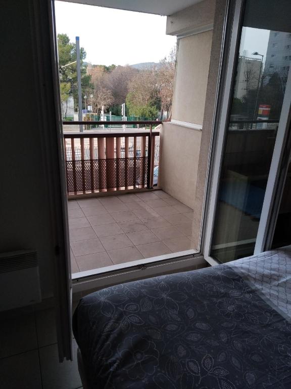 a bedroom with a view of a balcony with a bed at Rêve d une nuit d été in Aubagne