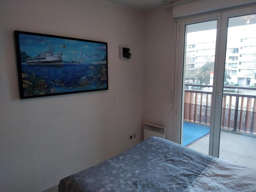 a bedroom with a painting of a ship on the wall at Rêve d une nuit d été in Aubagne