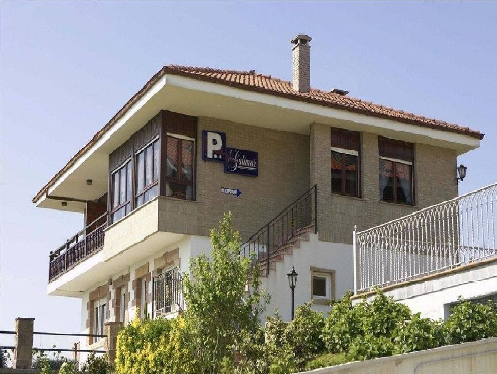 a building with a p sign on the side of it at Pensión Galimar in San Vicente de la Barquera