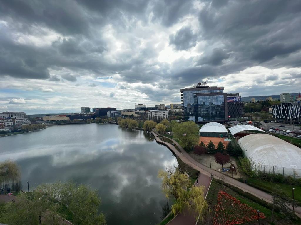 Blick auf einen Fluss mit Gebäuden und eine Stadt in der Unterkunft Lake View in Cluj-Napoca