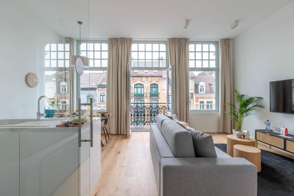 a kitchen and a living room with a couch at Sweet Inn - Churchill in Brussels