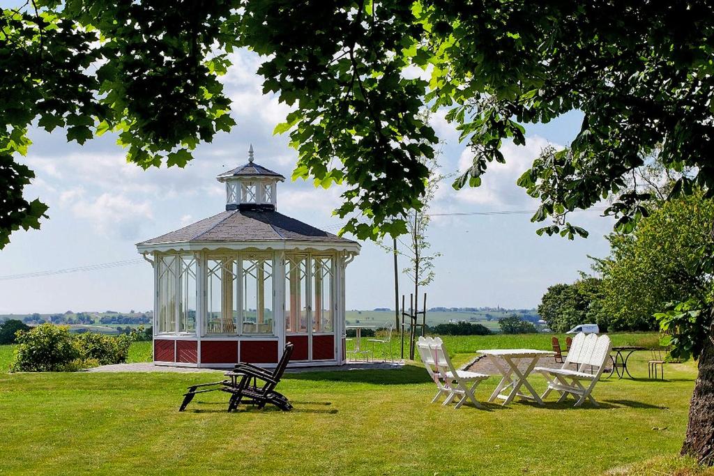 a gazebo in the middle of a field with chairs at Torsborgs Gård in Simrishamn