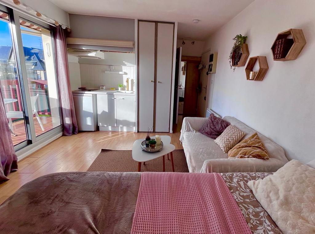 - un salon avec un canapé et une table dans l'établissement Chez Romy - studio équipé avec wifi - proche plage Deauville, à Tourgéville
