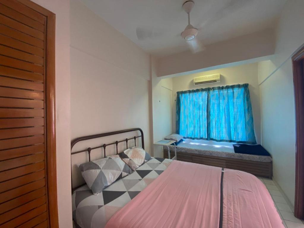 1 dormitorio con 1 cama y una ventana con cortinas azules en PUTRI HOMESTAY SEAVIEW PD, en Port Dickson