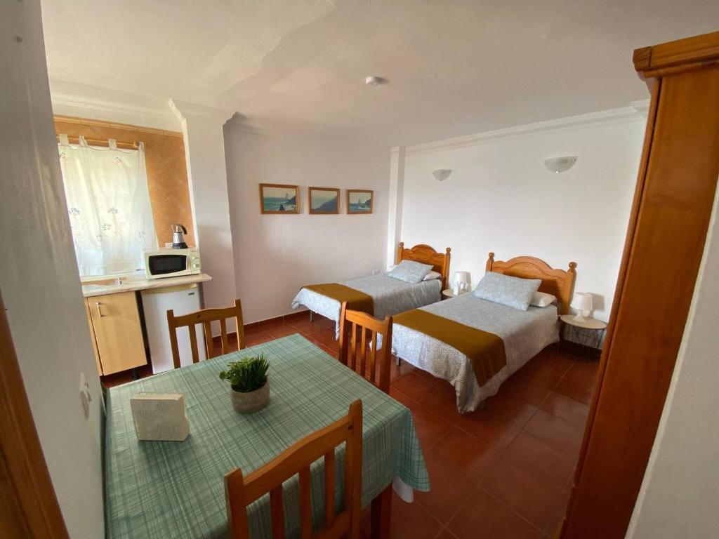 a room with two beds and a table in it at Cosy twin beds El Galeon in Santa Cruz de Tenerife