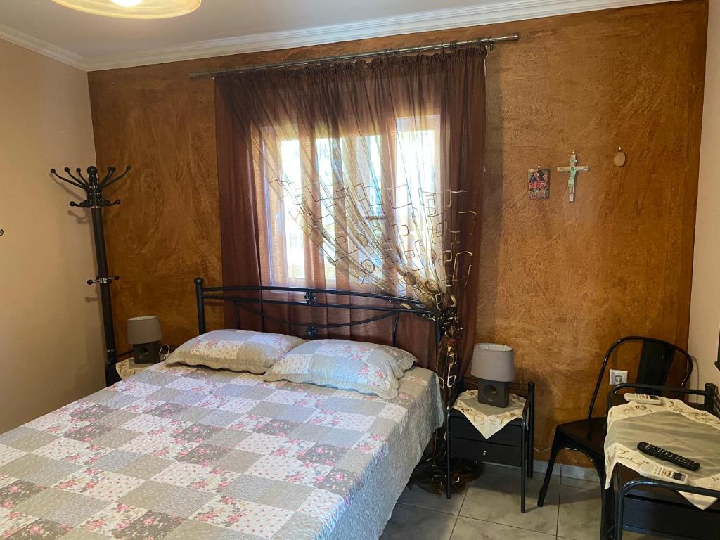 - une chambre avec un lit et une fenêtre avec une croix sur le mur dans l'établissement Three islands, à Mégare