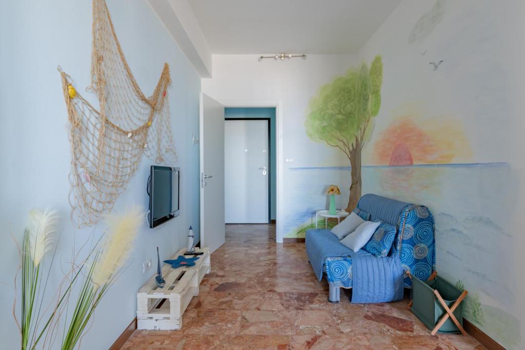 een woonkamer met een blauwe bank en een schilderij aan de muur bij La perla sul mare - YourPlace Abruzzo in Marina di San Vito