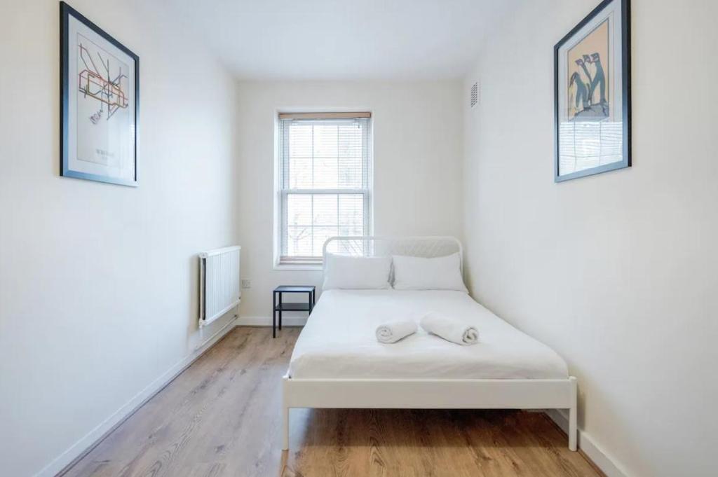 een wit bed in een witte kamer met een raam bij APlaceToStay Central London Apartment, Waterloo (STA) in Londen