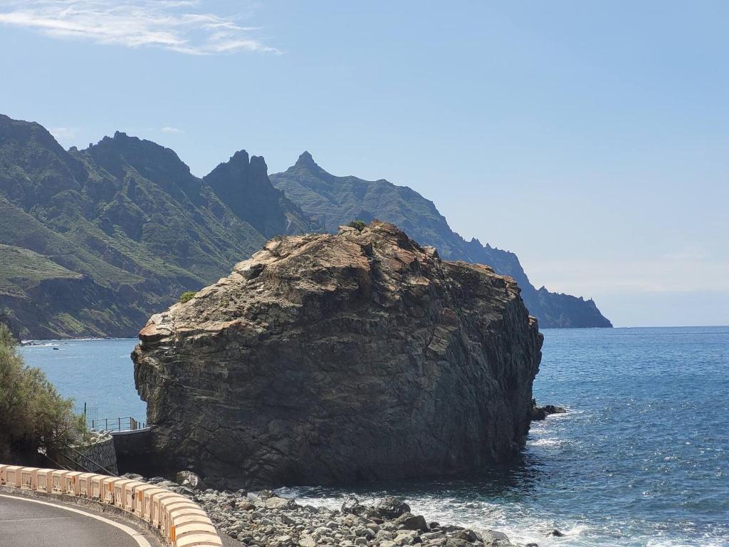 una gran roca en el agua junto a una carretera en Room in Lodge - Beautiful Sunsets from the Balcony El Roque, en Santa Cruz de Tenerife