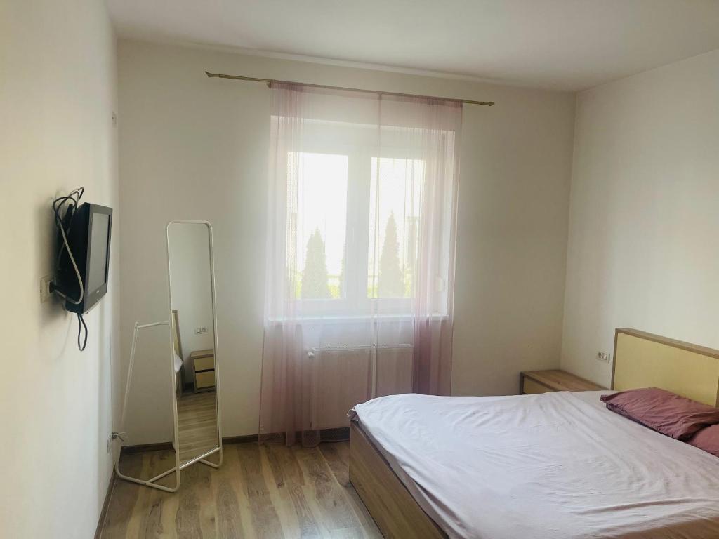 un dormitorio con una cama y una ventana en AMA, en Timisoara