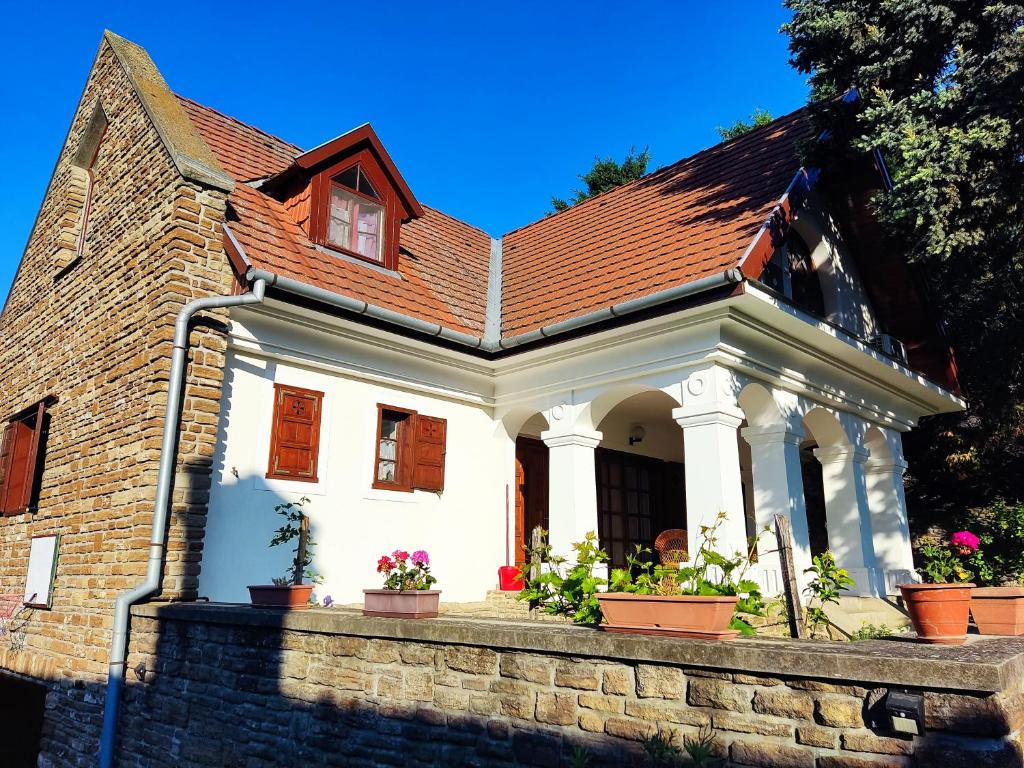 a white house with potted plants on a wall at Katerina Vendégház in Tihany