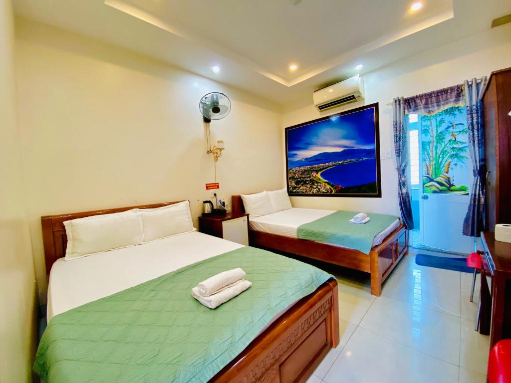 Habitación de hotel con 2 camas y ventana en Kinh Bac Hotel Quy Nhon, en Quy Nhon