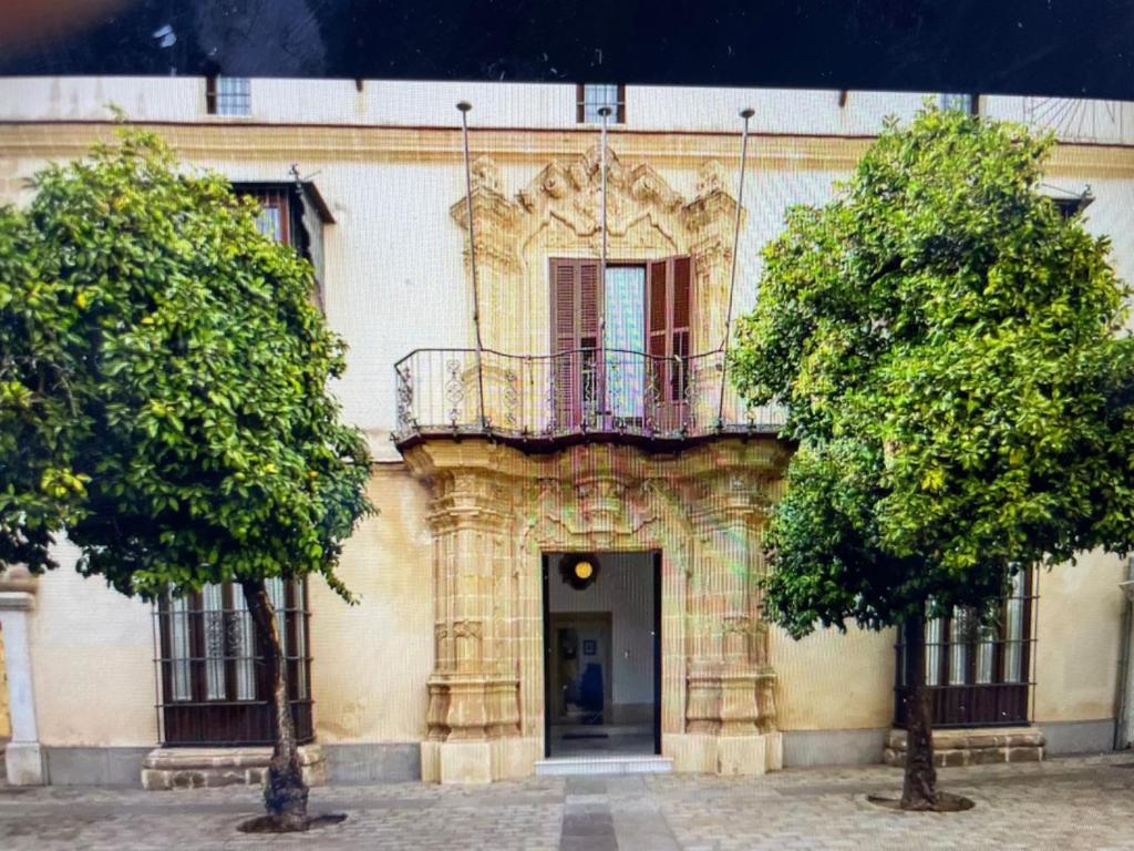 a building with a balcony on top of it at CASA PALACIO en Jerez de la Frontera con piscina privada in Jerez de la Frontera