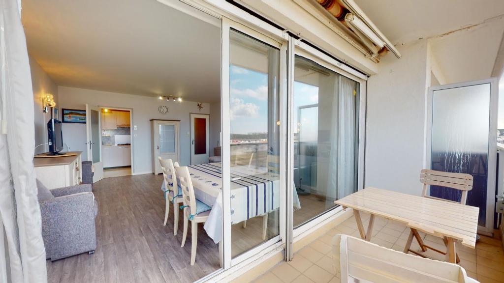 une salle à manger avec une table et des chaises et un balcon dans l'établissement La Cabine du Capitaine, à Saint-Gilles-Croix-de-Vie
