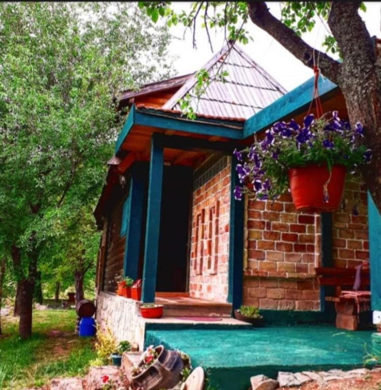 a small brick house with a blue roof at Chalet Etno Oaza near Airport in Sarajevo