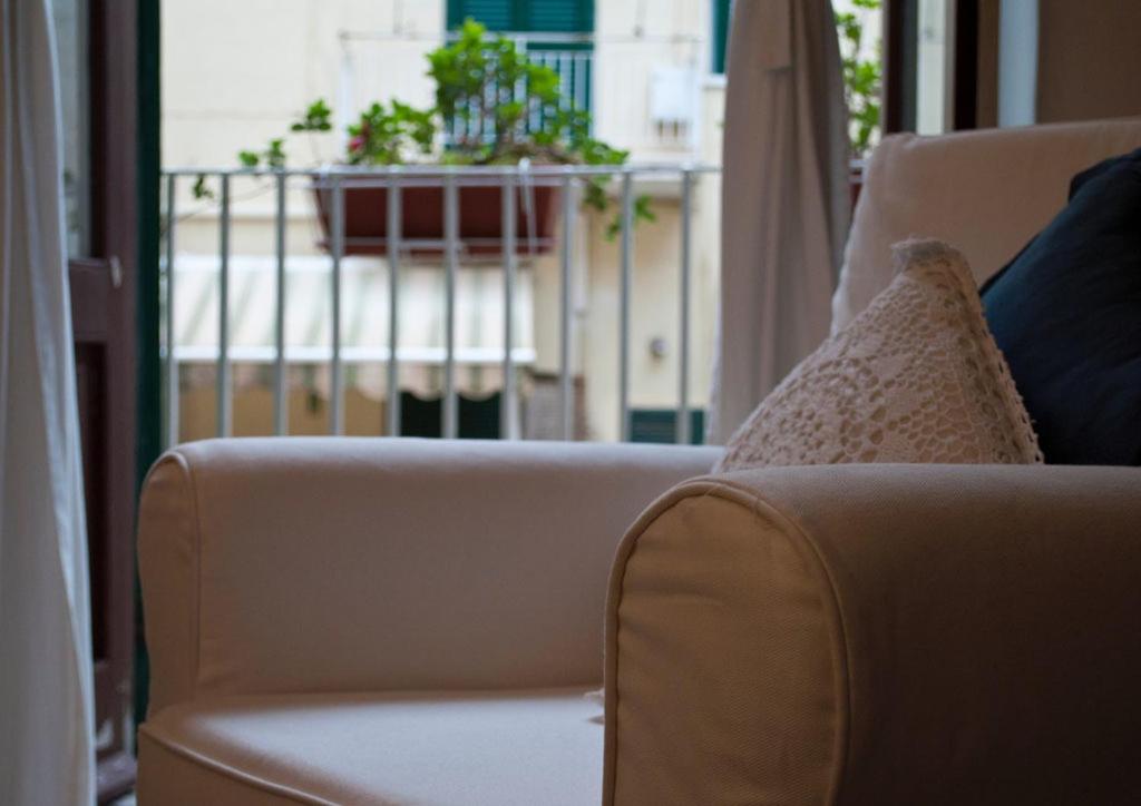 ein Sofa mit Kissen und eine Pflanze auf dem Balkon in der Unterkunft B&B Porto Trani in Trani