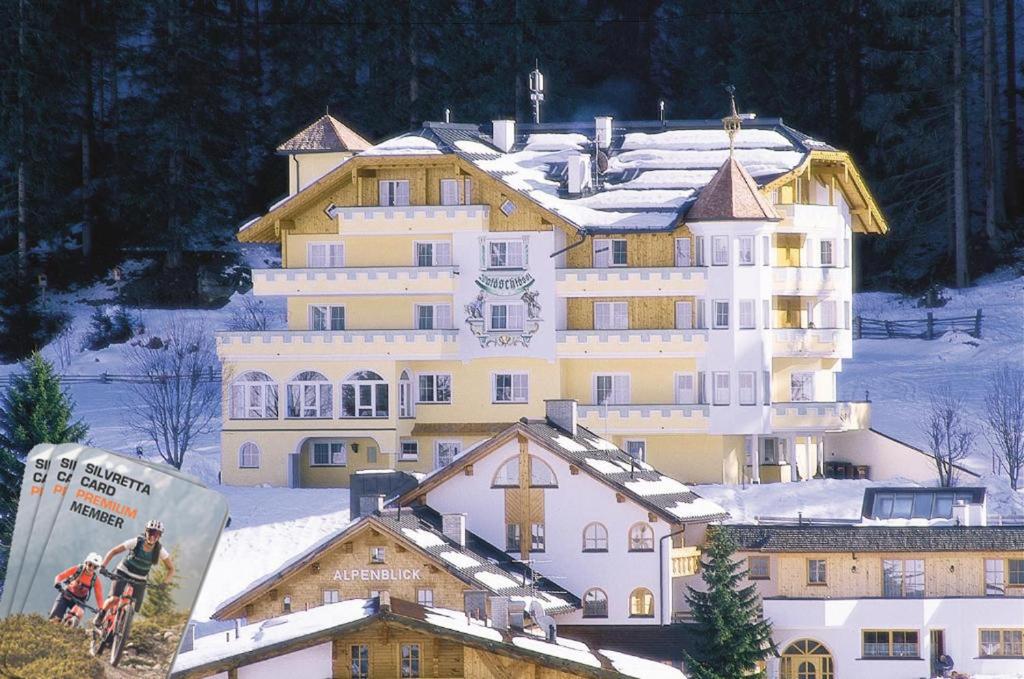 a large white building with snow on top of it at Hotel Garni Waldschlössl in Ischgl