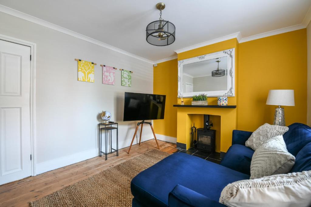 a living room with a blue couch and a tv at The Colebrook in Royal Tunbridge Wells