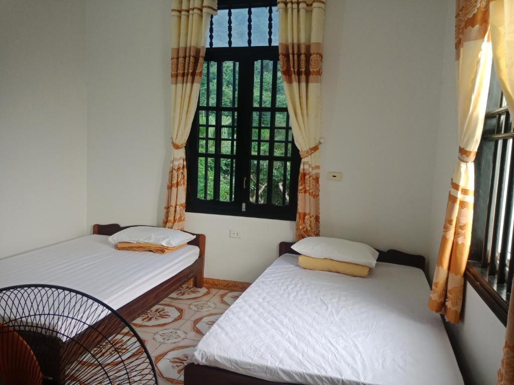 2 camas en una habitación con ventana en Cuc Phuong Hao Tham Homestay Hotel, en Phủ Nho Quan