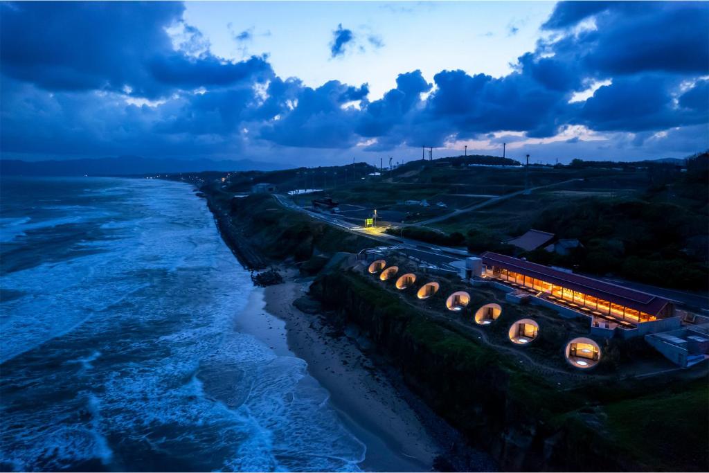 eine Gruppe von Lichtern an einer Wand neben dem Wasser in der Unterkunft Izumo HOTEL THE CLIFF 