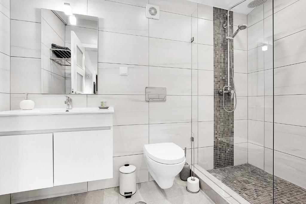 een witte badkamer met een toilet en een douche bij Quinta Aida Cottage and B&B Suites in Lagoa