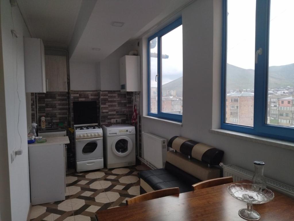a kitchen with a table and a stove and a washing machine at Apartment for good feelings in Sevan
