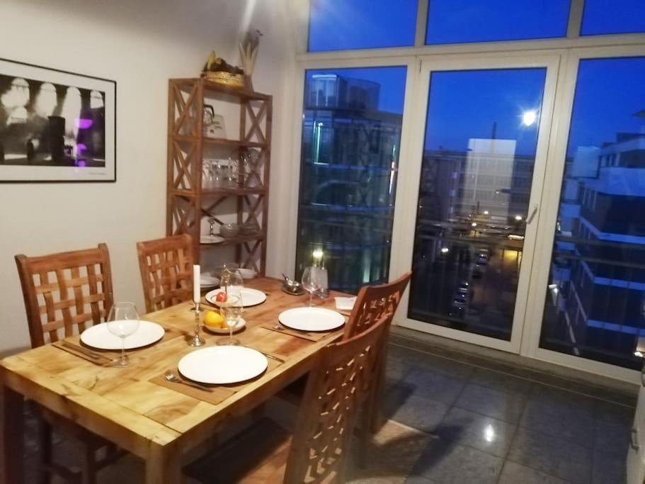 uma mesa de madeira num quarto com uma grande janela em Penthousewohnung 126 qm Bremen Innenstadt+ Dachterrasse em Bremen