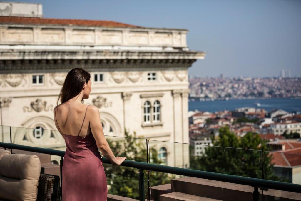 Eine Frau in einem Kleid, die auf eine Stadt blickt. in der Unterkunft Park Hyatt Istanbul - Macka Palas in Istanbul