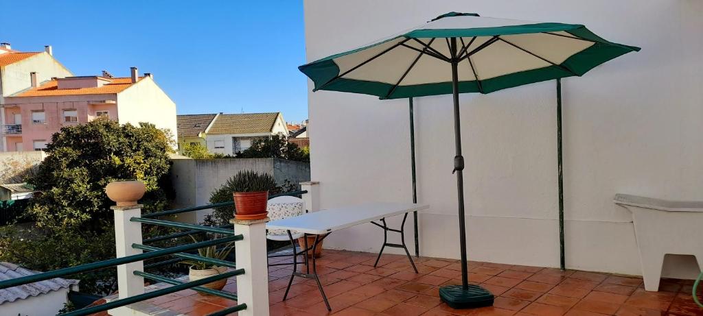 a patio with a table and an umbrella at Casa da Forja in Pinhal Novo