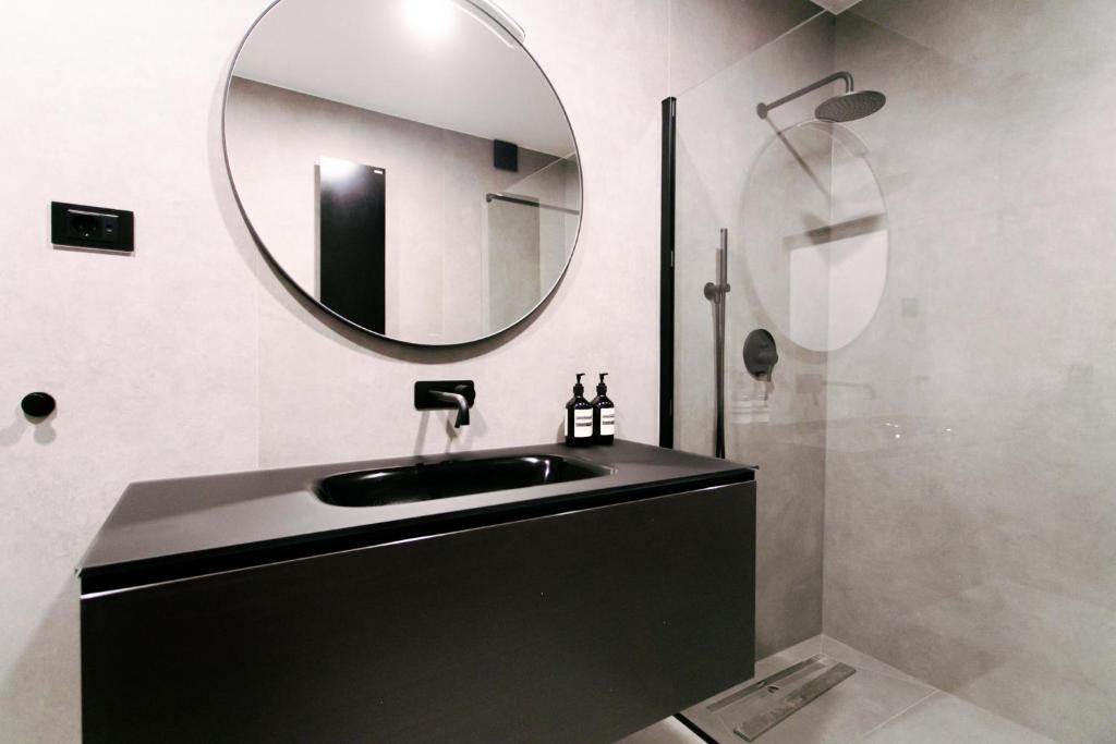 La salle de bains est pourvue d'un lavabo noir et d'un miroir. dans l'établissement City centre luxury apartment, à Zagreb